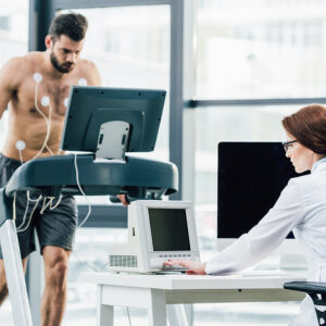 doctor at desk conducting endurance test with sportsman in gym