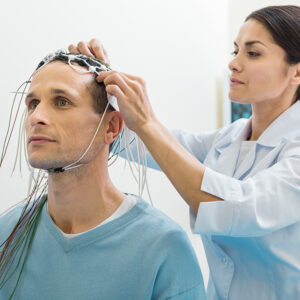 Female doctor putting electrodes on patients head